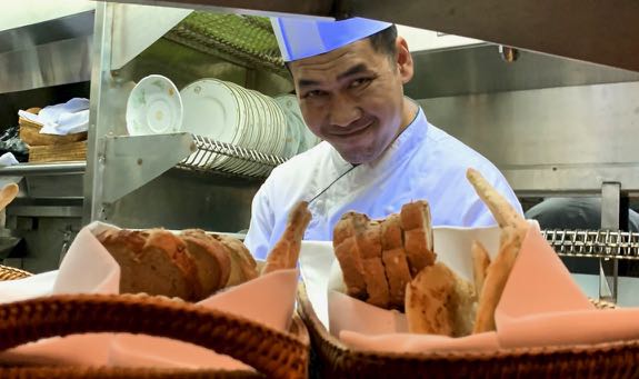 Chef smiling behind bread