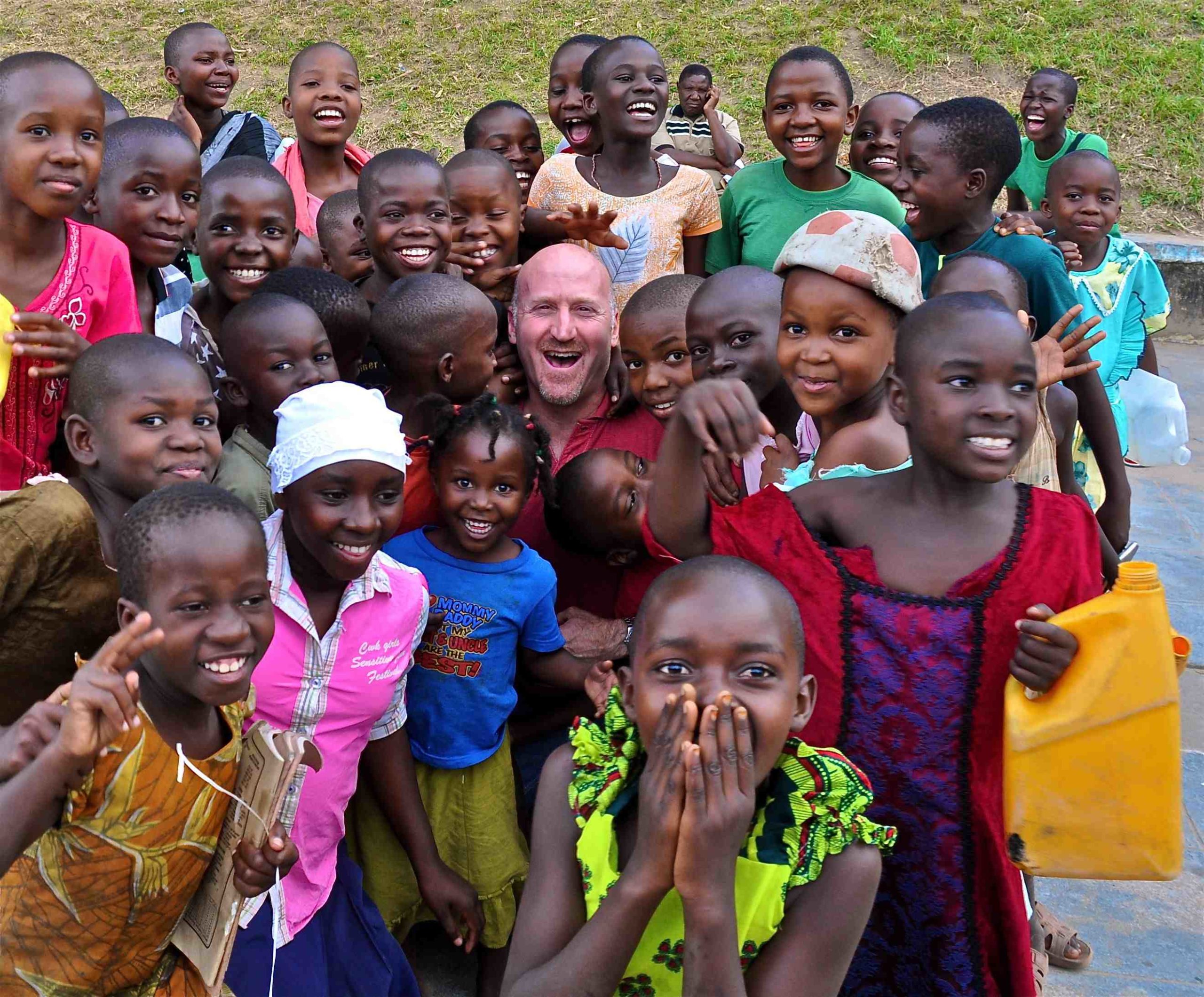 IRT traveler Jeff Grinspoon is welcomed by local schoolchildren during a stop on the Cape-Dar route in Mliba, Zambia. IRT Photo by Owen Hardy