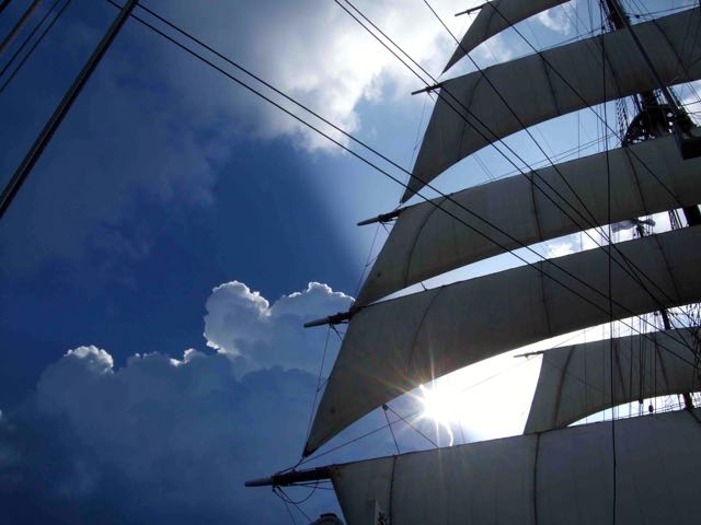 The Sea Cloud's distinctive square sails billow against a cloud-filled sky. IRT Photo by R. Fisher