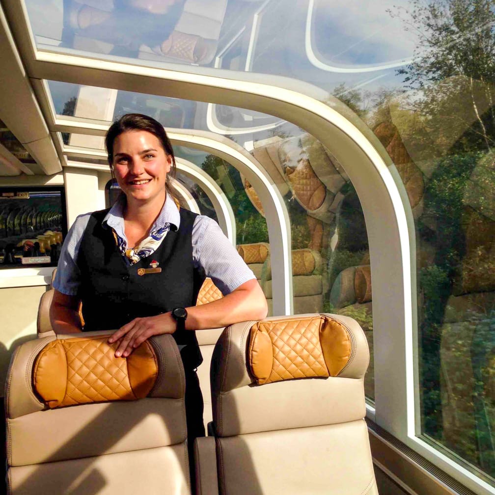 Stewardess standing by seats on the Canadian Rockies Getaway Circle journey