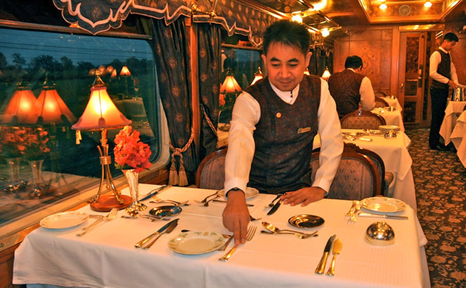 Waiter setting a table on the Kuala Lumpur-Bangkok by Luxury Train journey