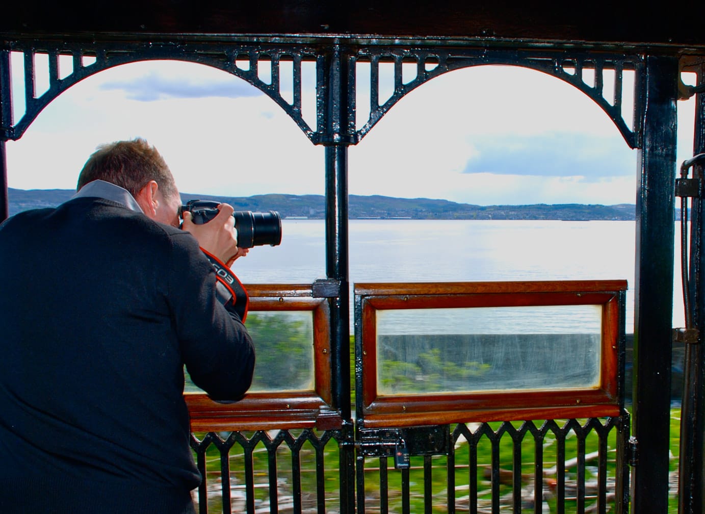 Man photographing ocean views while on the Western Scenic Wonders journey