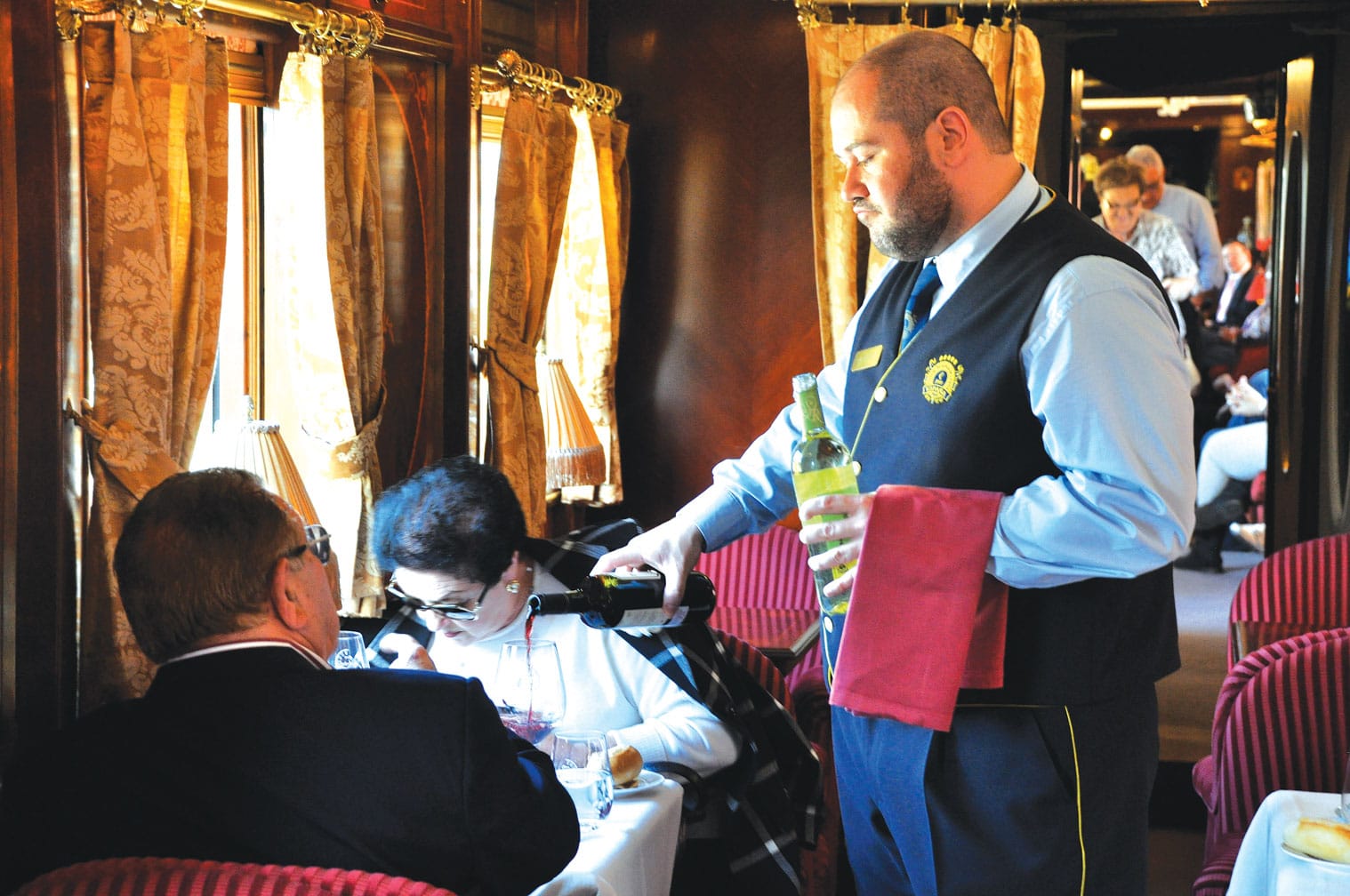 Server pouring wine on the Al Andalus train