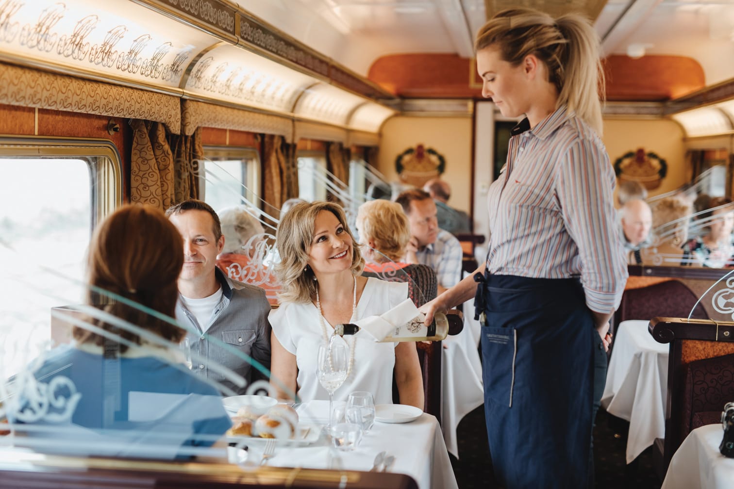 Server on the Ghan train pouring wine